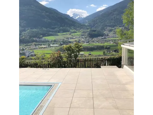 Taras z beżowego gresu Colosseo Barge przy basenie.